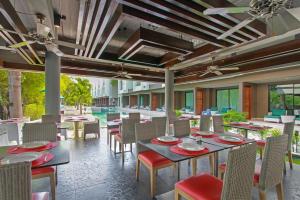 a dining room with tables and chairs and a pool at The Serenity Hua Hin in Hua Hin