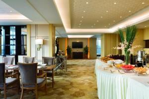 una sala da pranzo con tavoli e sedie in una camera d'albergo di Ramada Jiaxing a Jiaxing