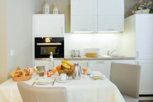 a white kitchen with a table with a basket of fruit at Ferienwohnung im Wasserwinkel in Quedlinburg +4 photos