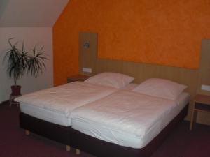 a bed with white sheets and pillows in a bedroom at Landgasthof Schubbkoarn's Ruh in Fulda