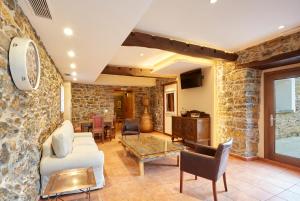 sala de estar con pared de piedra en Casa Josefa, en Murias