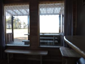 two windows in a room with a bench and a table at Camping Zaki house No 9 in Jūrkalne