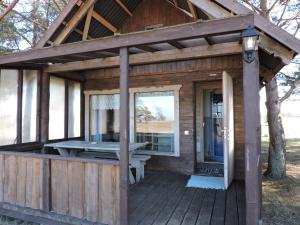 una cabina in legno con un tavolo da picnic su una terrazza di Camping Zaki house No 9 a Jūrkalne