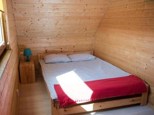 a bedroom with a bed in a wooden cabin at Domki letniskowe w Kopalinie in Kopalino