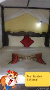 1 dormitorio con 1 cama con Marvin the marthog gmaxwell gmaxwell en Warung Santa Fe and Bungalows, en Amed