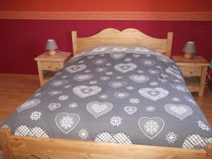 een bed met een zwart-witte sprei met harten bij La Ferme du Vieux Sapin in La Bresse