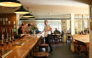 a man standing at a bar in a restaurant at The Turtley Corn Mill in South Brent +16 photos