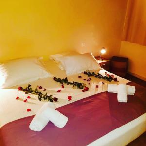 Una cama con flores en una habitación en Hotel Les Hauts de Porto-Vecchio, en Porto Vecchio