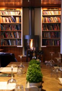 een tafel met een open haard in een kamer met boeken bij The Turtley Corn Mill in South Brent