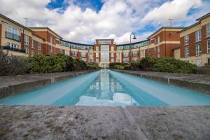 uma longa piscina de água em frente a um edifício em Spacious Luxury Apartments in Windsor em Windsor