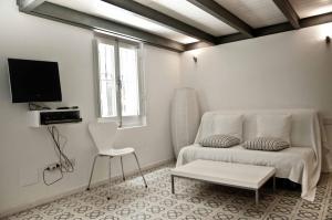 a white living room with a couch and a chair at Barceloneta Suites Apartments Market in Barcelona