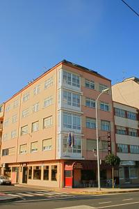a large building with a clock on the front of it at Hotel Kensington in Narón