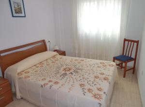 a bedroom with a bed and a chair and a window at APCOSTAS - Marina Mar 2a Línea in Oropesa del Mar +33 photos