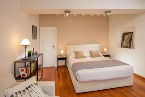 a bedroom with a white bed and a couch at Cozy Studio Parlamento in Rome