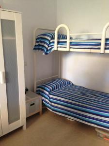 ランポーヤにあるTramuntana - L'Ampollaの二段ベッド2組が備わる小さな部屋で、ドアがあります。