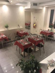 a dining room with red tables and chairs at Hotel La Madonnina in Milan