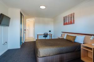 a bedroom with a bed and a desk at Canning Bridge Auto Lodge in Perth