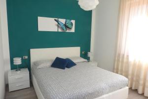 een slaapkamer met een bed met een blauwe muur bij Villa Fiori in Malcesine