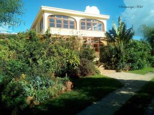 Una casa grande con muchas plantas delante. en SOUIMANGA-HOTEL en Antsirabe