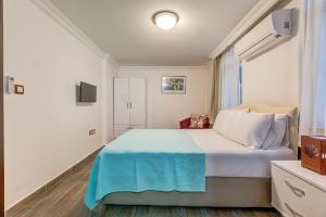 a bedroom with a large bed with a blue blanket at Nefes Hotel in Ayvalık