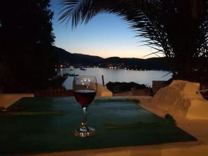 a glass of wine sitting on top of a table at Buena Vis-ta Apartments with the Sea View in Vis