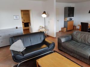 a living room with a leather couch and a table at An attractive apartment in Gerolstein in Gerolstein