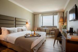 a hotel room with a bed with a tray of fruit on it at HF Ipanema Park in Porto +21 photos