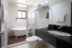 een witte badkamer met toilet en wastafel bij Penghu Little Apple B&B in Magong