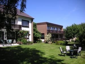 a yard with chairs and a table in front of a house at Pension Haus Baltic in Dahme