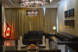 a living room with a couch and a chandelier at Ista Suites Seef in Manama