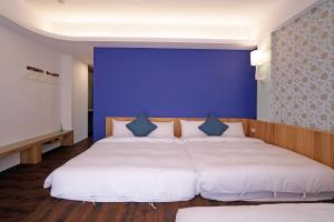 Een bed of bedden in een kamer bij Penghu Little Apple B&B