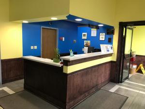 een lobby met een blauwe muur en een balie bij Days Inn by Wyndham Hillsboro in Hillsboro