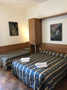 ローマにあるホテル ボロネーゼのベッド2台が備わるホテルルーム内のベッド2台
