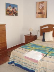 Los Romeros的住宿－Ocio Aventura Rural，一间卧室配有一张床、梳妆台和一张睡床。