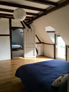 a bedroom with a blue bed in an attic at La Ferrière in Pissy-Pôville