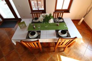 a dining room table with a white table cloth and chairs at Bibic Nature Lodge in Balmazújváros