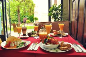 a table with plates of food and glasses of orange juice at Casa Georgius Krauss Sighisoara in Sighişoara