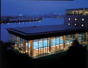 a building with a swimming pool on top of it at Canary Riverside Plaza Hotel in London