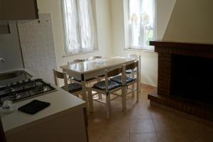 a kitchen with a table and chairs and a fireplace at Casa di Tony in Montegiorgio