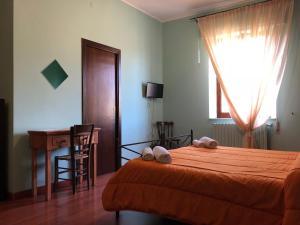 a bedroom with a bed and a desk and a window at Edelweiss in Randazzo