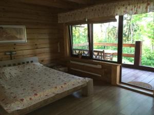 a bedroom with a bed in a log cabin at Rancho Randevu in Koknese