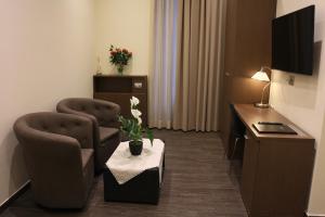 a hotel room with two chairs and a table in a room at Hotel La Madonnina in Milan