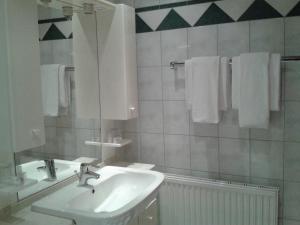 a bathroom with a sink and a mirror and towels at Landhotel Gersbach-Gut in Henndorf am Wallersee