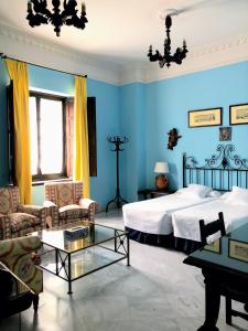 Dormitorio azul con cama y mesa en Hotel Casa Imperial, en Sevilla