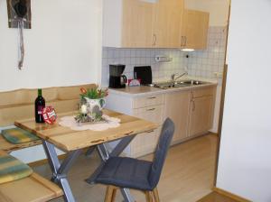 a kitchen with a wooden table with chairs and a sink at Ferienwohnungen Bloier in Bad Birnbach
