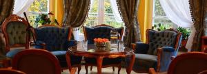 Habitación con mesa, sillas azules, mesa y mesa. en Astoria - Willa Literatów, en Zakopane