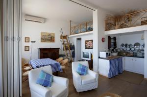a living room with white chairs and a table at Residence Le Dune Club in Varigotti