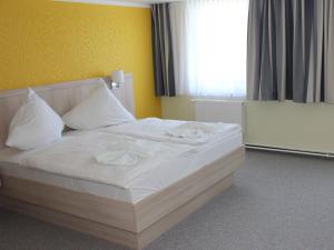 ヴィッテにあるFerienwohnung Suderendeのベッドルーム1室(白いシーツと枕のベッド1台付)