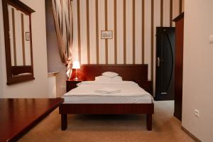 a bedroom with a bed with a wooden head board at Rynek 6 retro pub & hostel in Radom