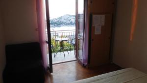 Zimmer mit einer Tür, die auf einen Balkon mit einem Tisch führt. in der Unterkunft Pansion Panorama Dubrovnik in Dubrovnik